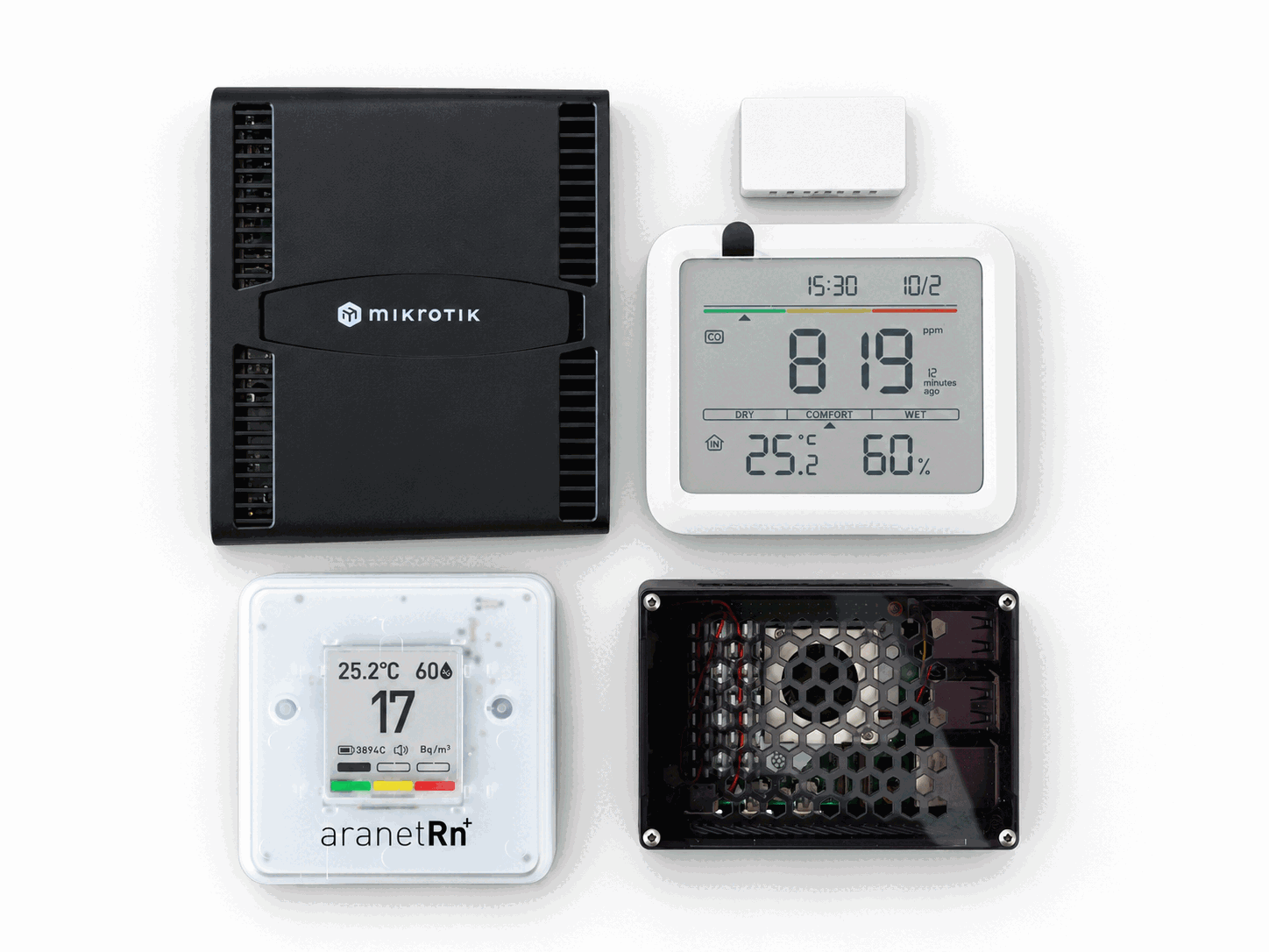A studio arrangement of a MikroTik router, compact compute unit, and air quality monitors.